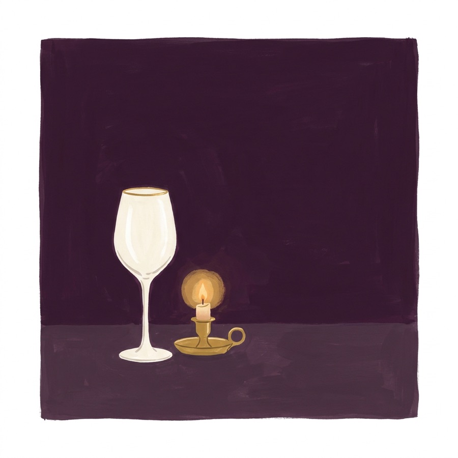 An empty glass beside a candle
